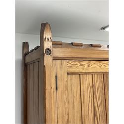 Late 19th century pitch pine wardrobe press cupboard, two panelled doors enclosing hanging hooks, two drawers below, carved with flower head roundels 