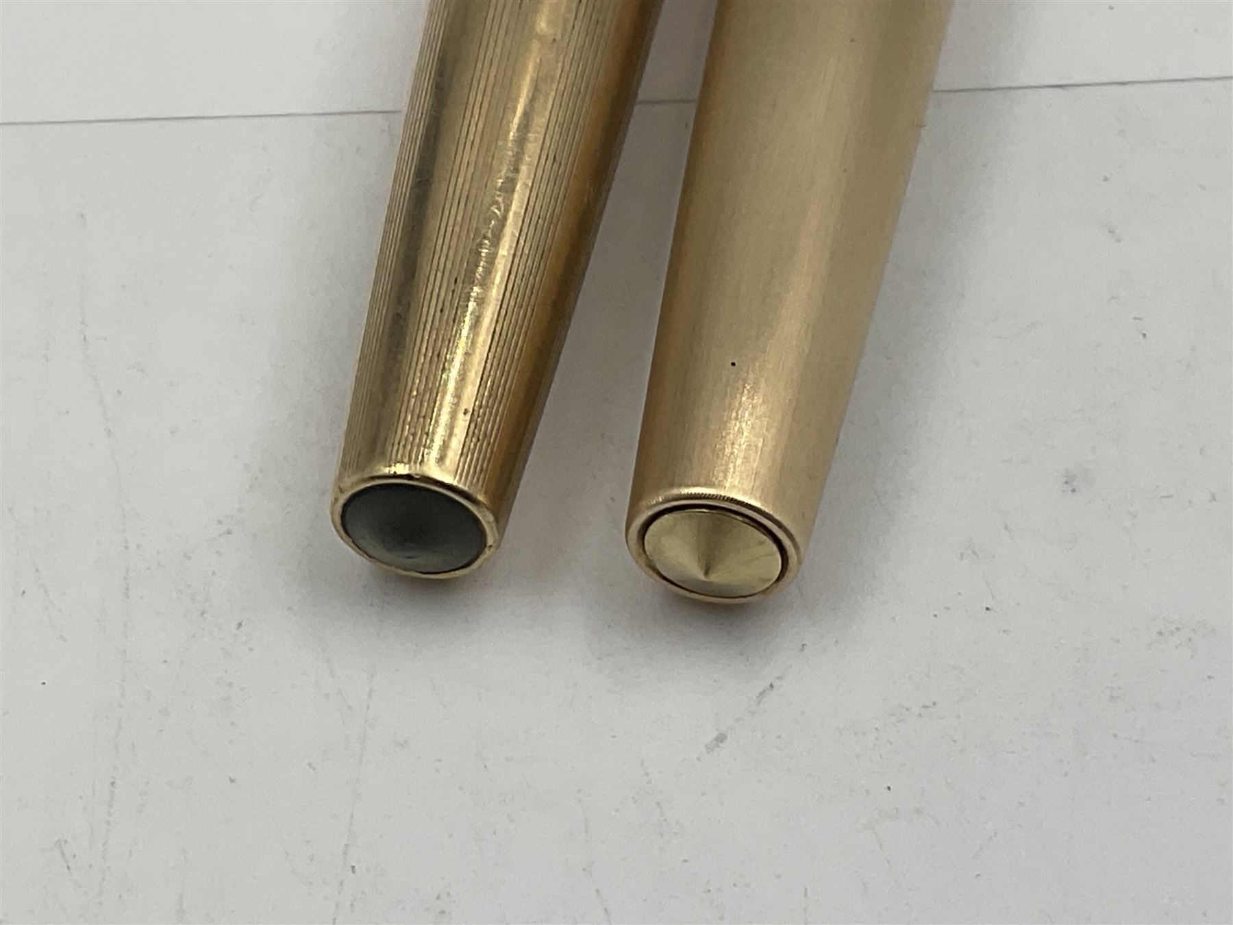 Three rolled gold Parker fountain pens, comprising an example with a gold nib marked 14K 585 and barrel with a shell stamp, a Parker 61 fountain pen with inset gold arrow to the nib, and another similar, all with striated decoration and arrow clips to the caps, L13cm, one with box