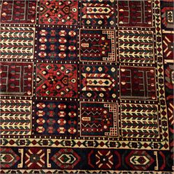 Bakhtiari wool rug, compartmented garden design field with panels of stylised trees, flowers and geometric motifs, enclosed by dark blue main border with repeating floral medallions and guard stripes