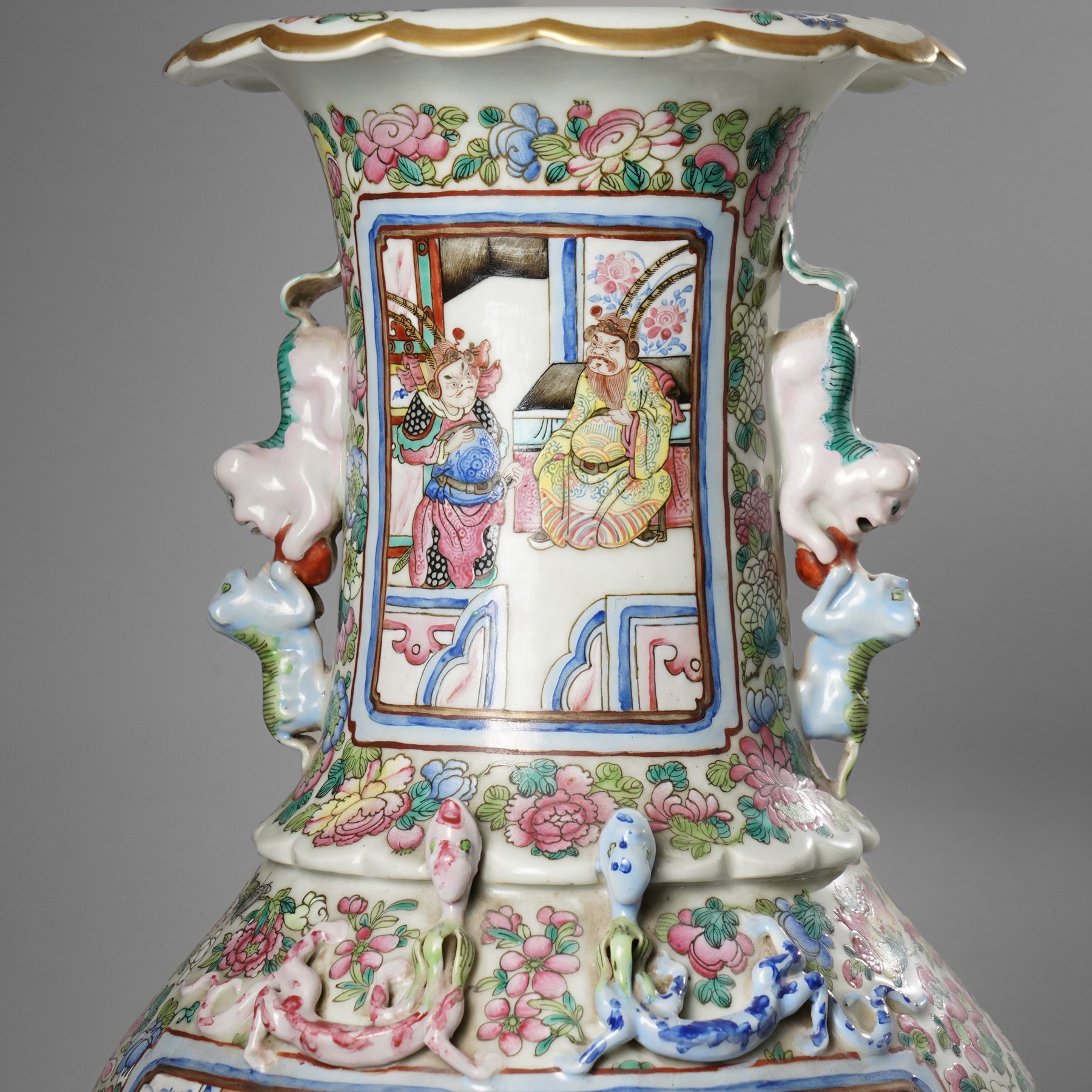 Large pair of 19th century Cantonese famille rose vases, each painted with various courtly scenes, including a display of warriors fighting on horseback before an official and his attendants, double Buddhist lion handles and applied at the shoulders with chilong, the lower band painted with Greek key motif, H58cm (2)