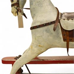 20th century carved and painted rocking horse, with original dappled paint finish, studded leather saddle and reins, on later red and black swing frame