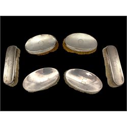Six silver mounted dressing table brushes, comprising set of four, with engine turned decoration and engraved monogram and a pair of oval brushes with engraved initials, all hallmarked