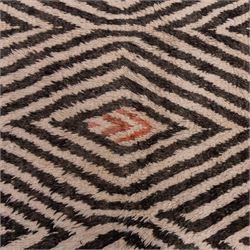 Moroccan Berber hand-knotted rug, of rectangular form, ivory ground decorated with bold, repeating lozenge motifs defined by alternating charcoal grey linear bands, with a striking geometric lattice and chevron with diamond designs, enclosing smaller stylized devices in soft blush tones, with fringe ends