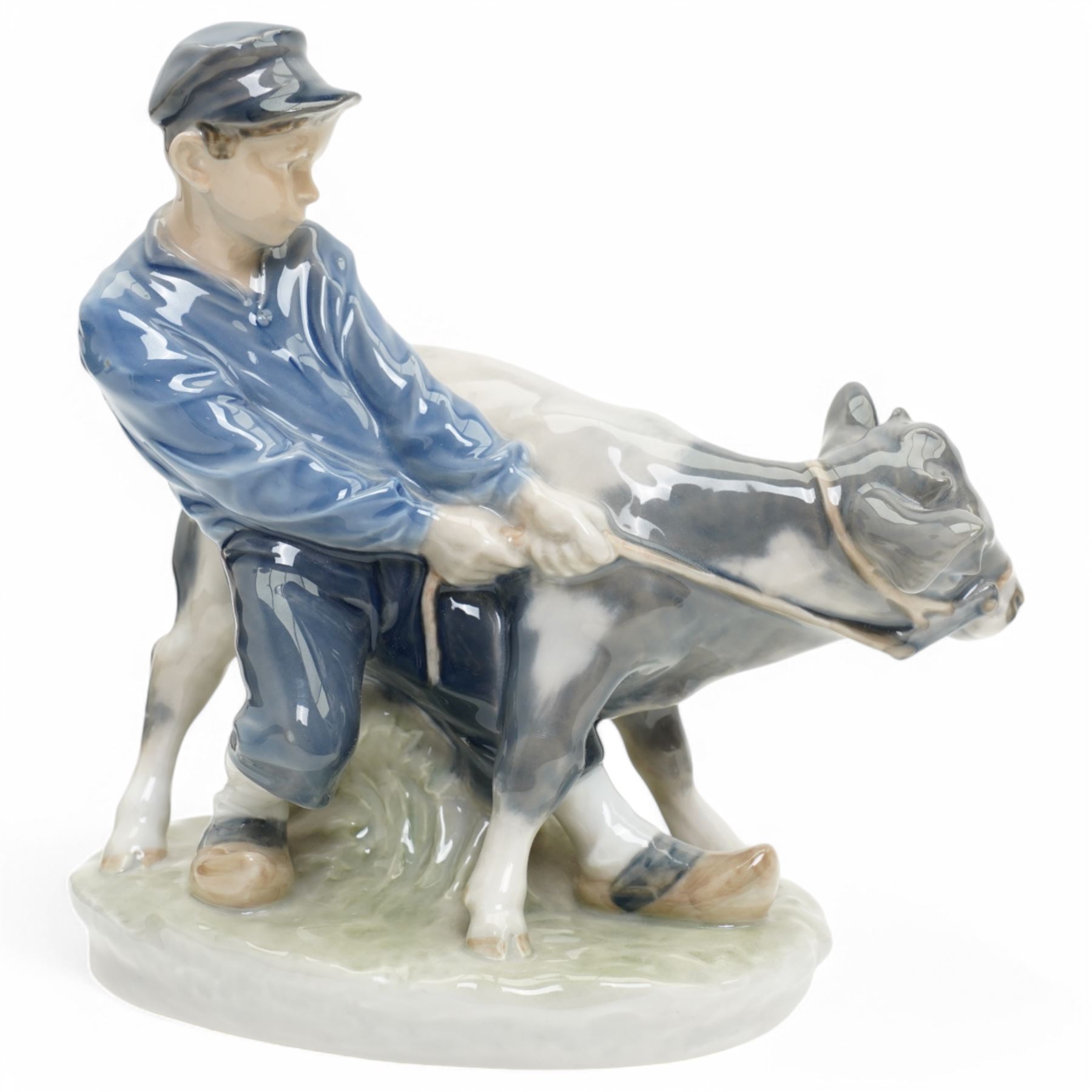 Three Royal Copenhagen figures, including Boy leading two Calves no. 1858, Boy with Calf no. 772, and Girl feeding Calf no. 779