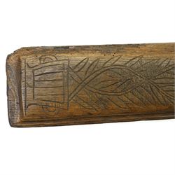 19th century oak mangle board, incised date 1864, decorated with a flower emerging from a pot, W51cm 