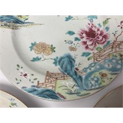 Three 18th century Chinese Famille Rose plates, the first example enamelled with blossoming peonies, rockwork and fence, the other two examples of similar design, decorated with blossoming peonies and sprigs within shaped inner borders, each approximately D23cm