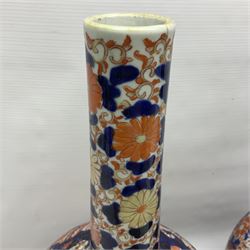 Pair of large 19th century Japanese Imari porcelain bottle vases, painted with shaped reserves of peonies, chrysanthemums and prunus blossom, each H46cm