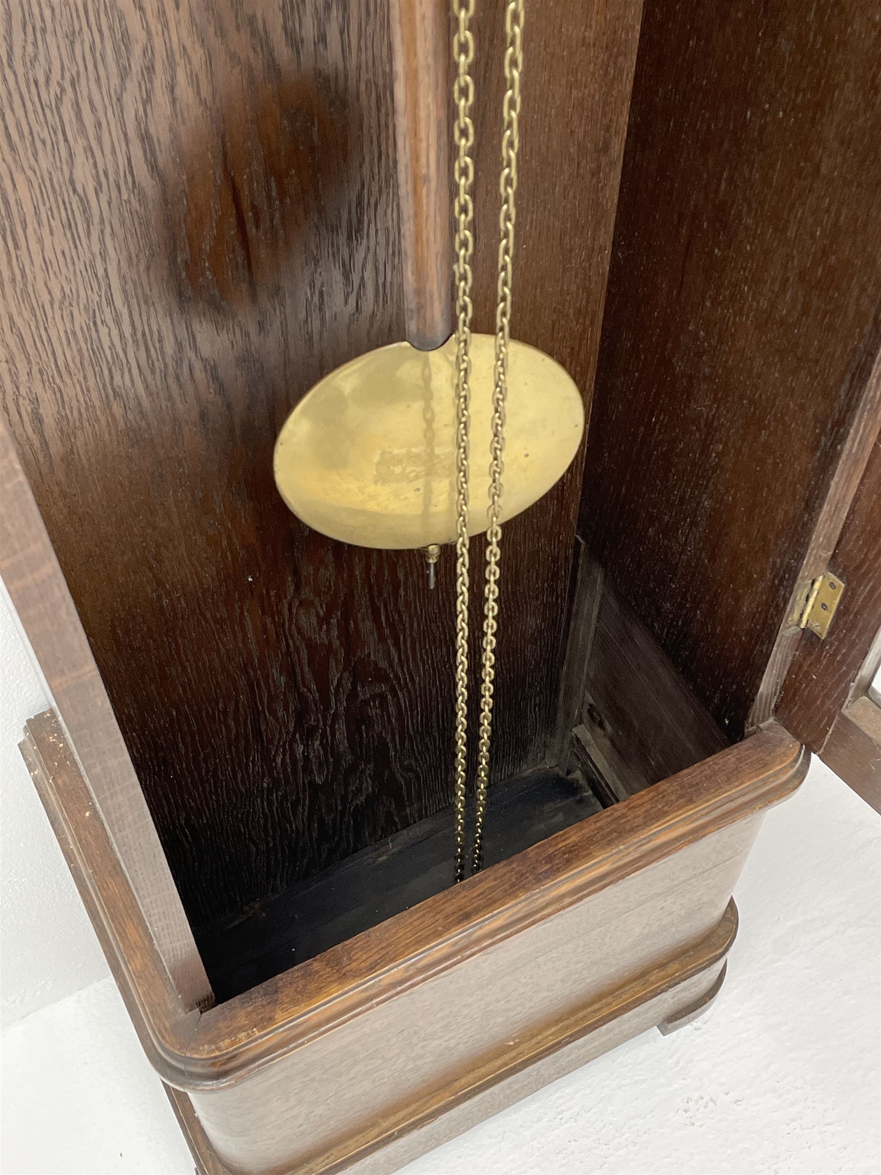 Early 20th century Art Deco oak longcase clock, circular dial with roman numerals and minute track, dial signed 'Barnby & Rust, Hull', twin chain driven movement striking the hours on gong rods. With weights and Pendulum.