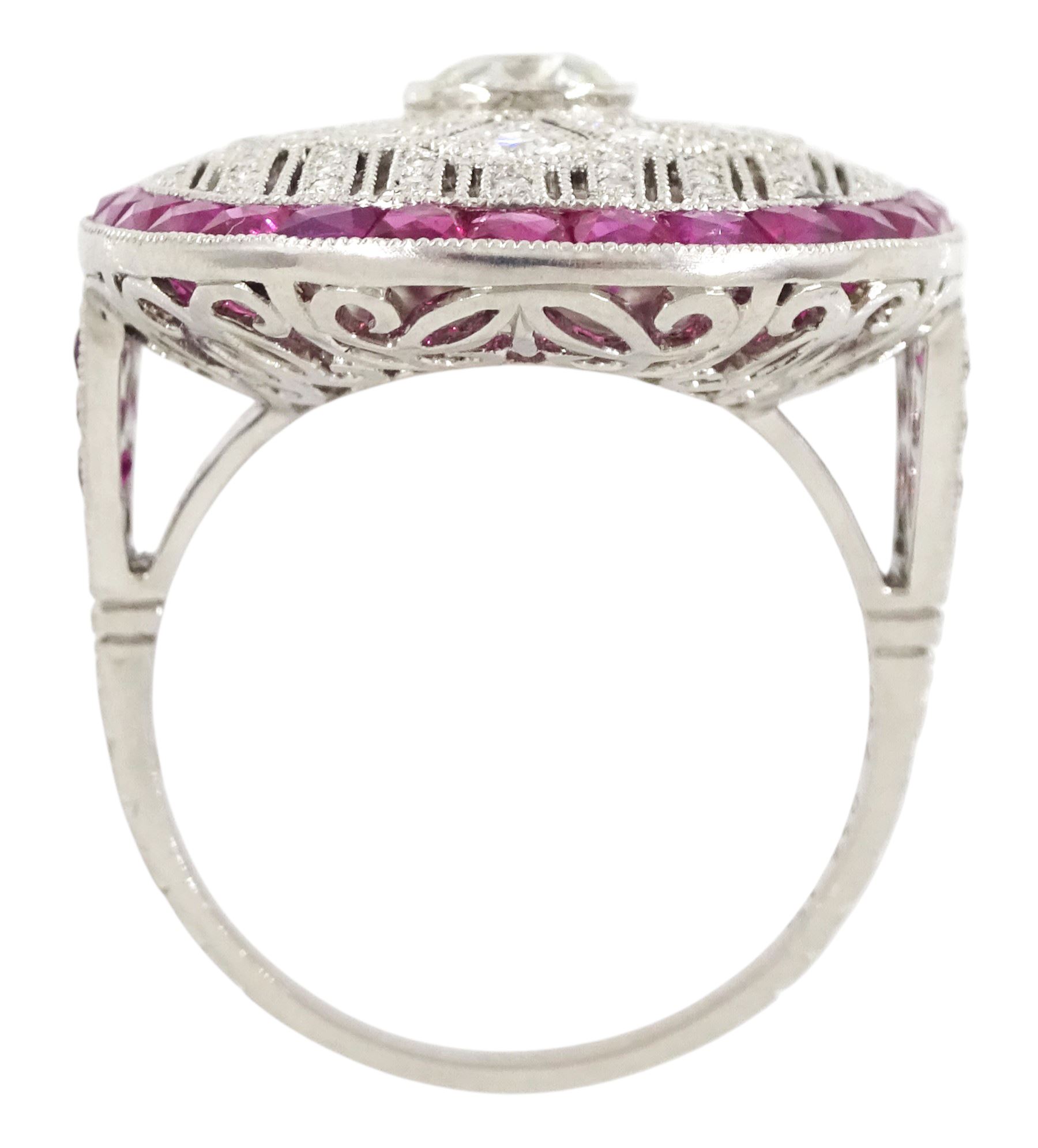 Platinum diamond and ruby oval cluster ring, principal transitional cut diamond of approx 0.55 carat, with milgrain set openwork diamond surround and calibre cut ruby border, with ruby and diamond shoulders