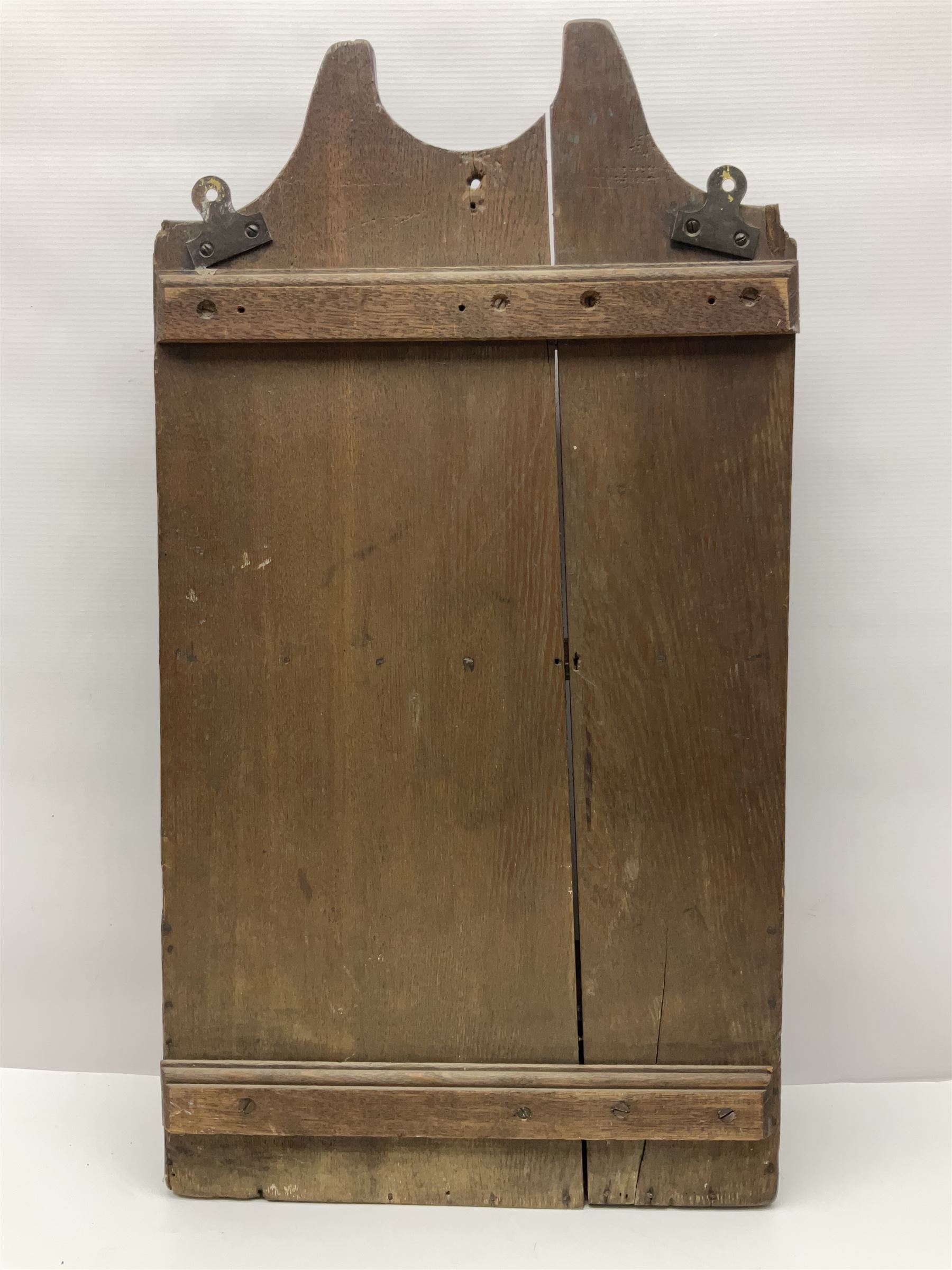 George III oak spoon rack and candle box, the rectangular backplate with shaped  pediment and two six aperture spoon racks, above a candlebox with hinged cover, with various brass spoons and a pair of brass candle snuffers, H56.5cm, W35cm, D14cm 