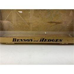 Benson and Hedges countertop glazed display cabinet, the glass hinged lid with white labelling of various cigarettes and cigars, the gilded metal bands with black lettering, W38cm D33cm H8cm