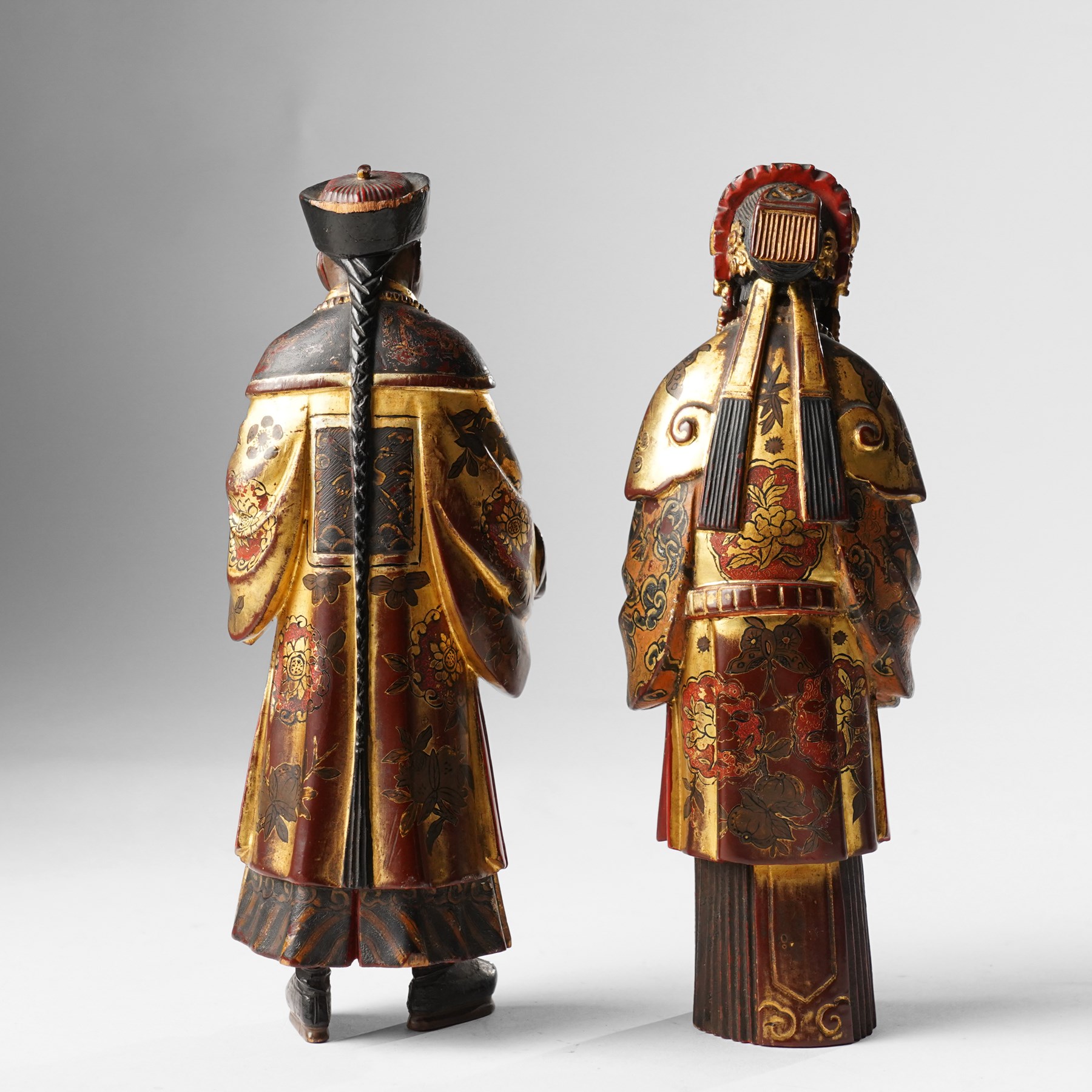 Pair of Chinese carved wooden lacquered figures, in ceremonial dress, possibly wedding attire, highlighted throughout in gilt, H22cm