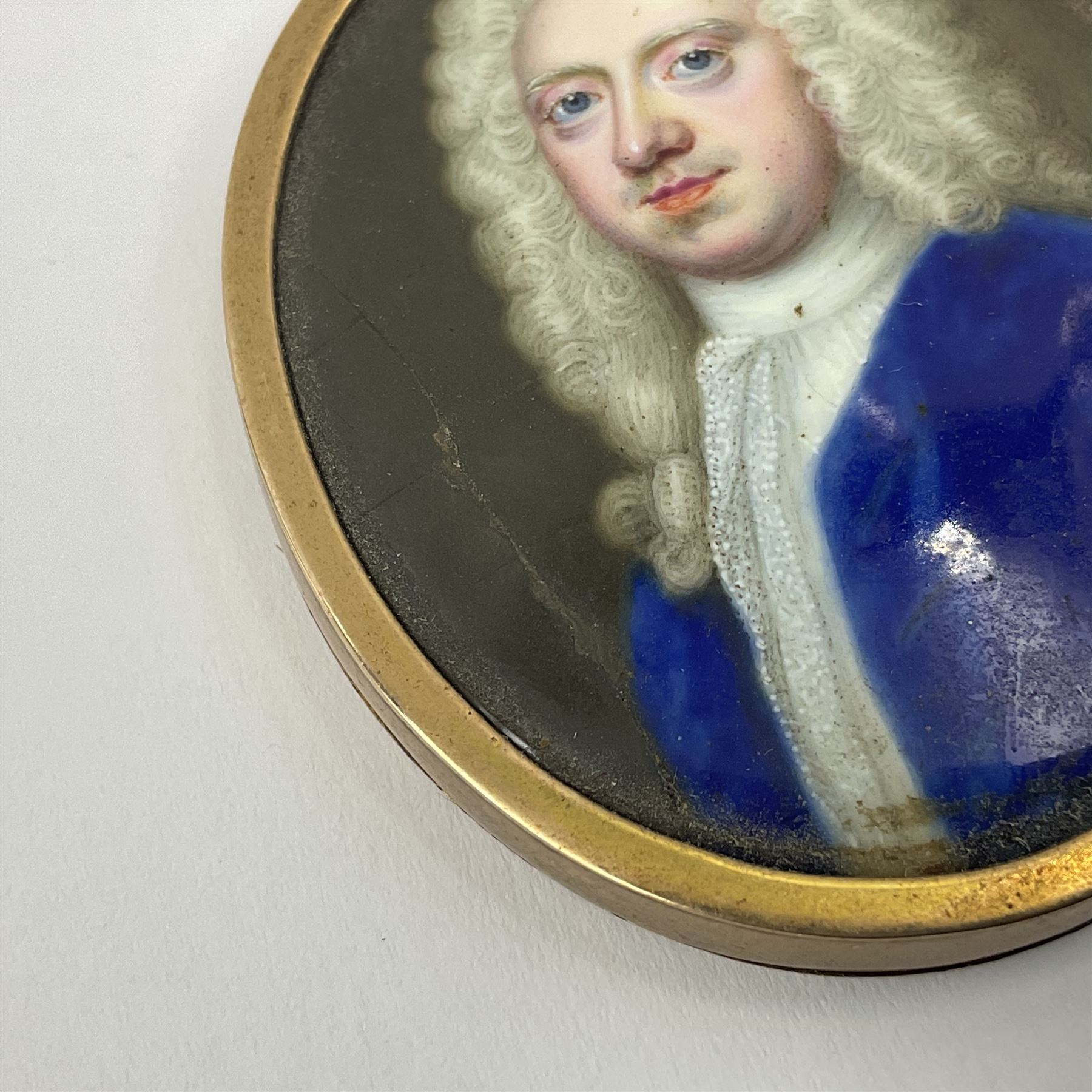 In the manner of Christian Zincke (German 1683-1767)
Portrait miniature upon enamel, circa 1750
Head and shoulder portrait of a gentleman in blue coat, possibly George II 
Within 9ct gold frame with ivory panel verso
Oval 4.5cm x 3.5cm

This item has been registered for sale under Section 10 of the APHA Ivory Act