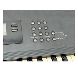 Korg M1 keyboard synthesiser, 61 velocity-sensitive keys with integrated multi-effects and eight-track sequencer, mounted on an adjustable black tubular X-frame stand with rubber end caps