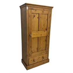 Pine single wardrobe, enclosed by single panelled door, fitted with single drawer, on plinth base 
