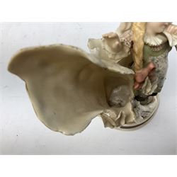 Late 19th century continental spill vase as a young girl standing beside an open tree trunk H21cm; and three German bisque figures (4)