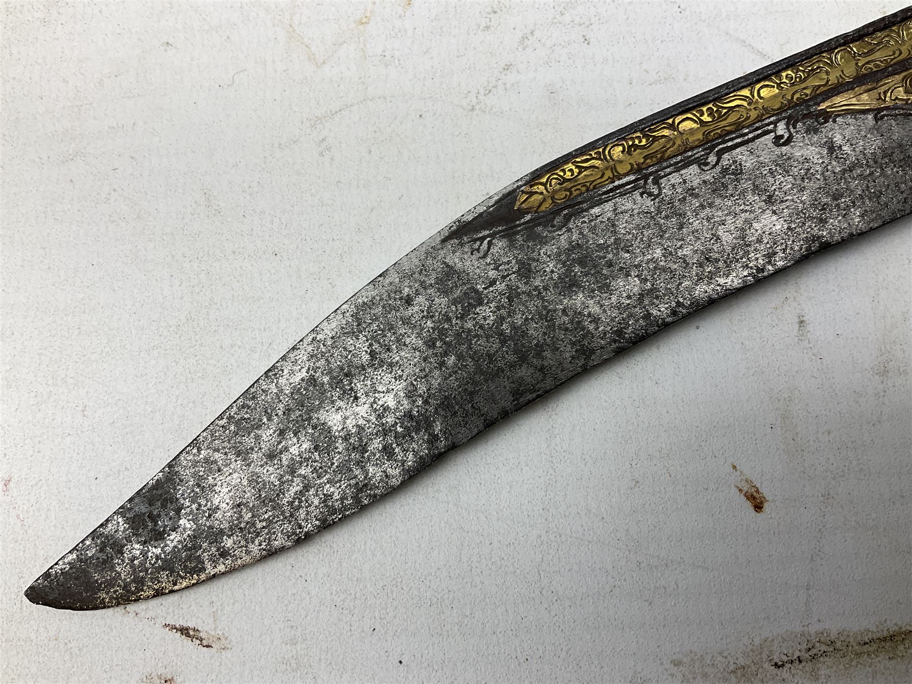 19th century Singhalese knife pia kaetta, the 20cm steel blade inset with yellow and white metal, with metal mounted carved pistol grip, in plain wooden scabbard L33cm overall