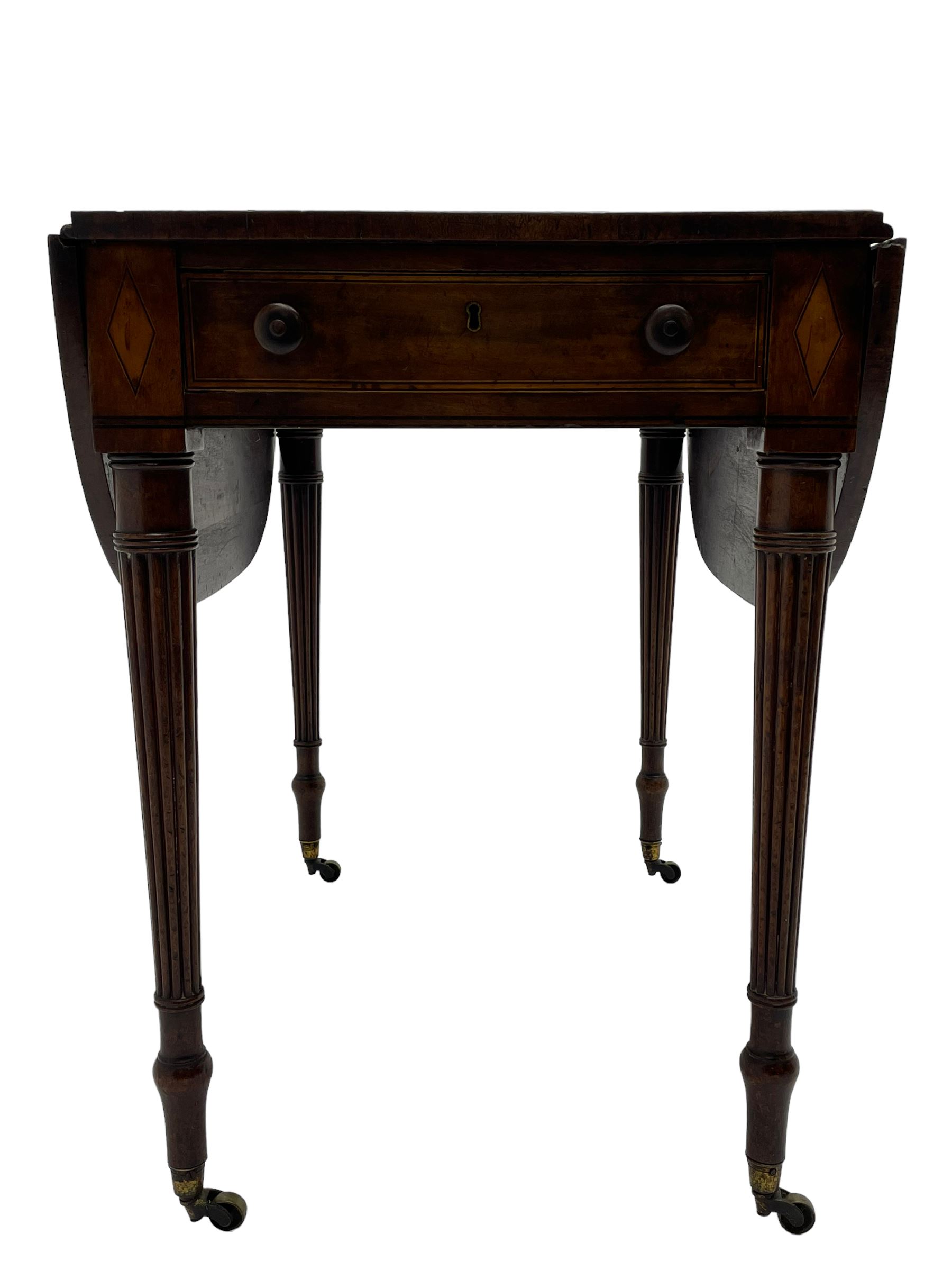 George III mahogany Pembroke table, drop-leaf oval top with satinwood band, fitted with single end drawer, inlaid with satinwood lozenge motifs, on turned and reeded supports with brass cups and castors