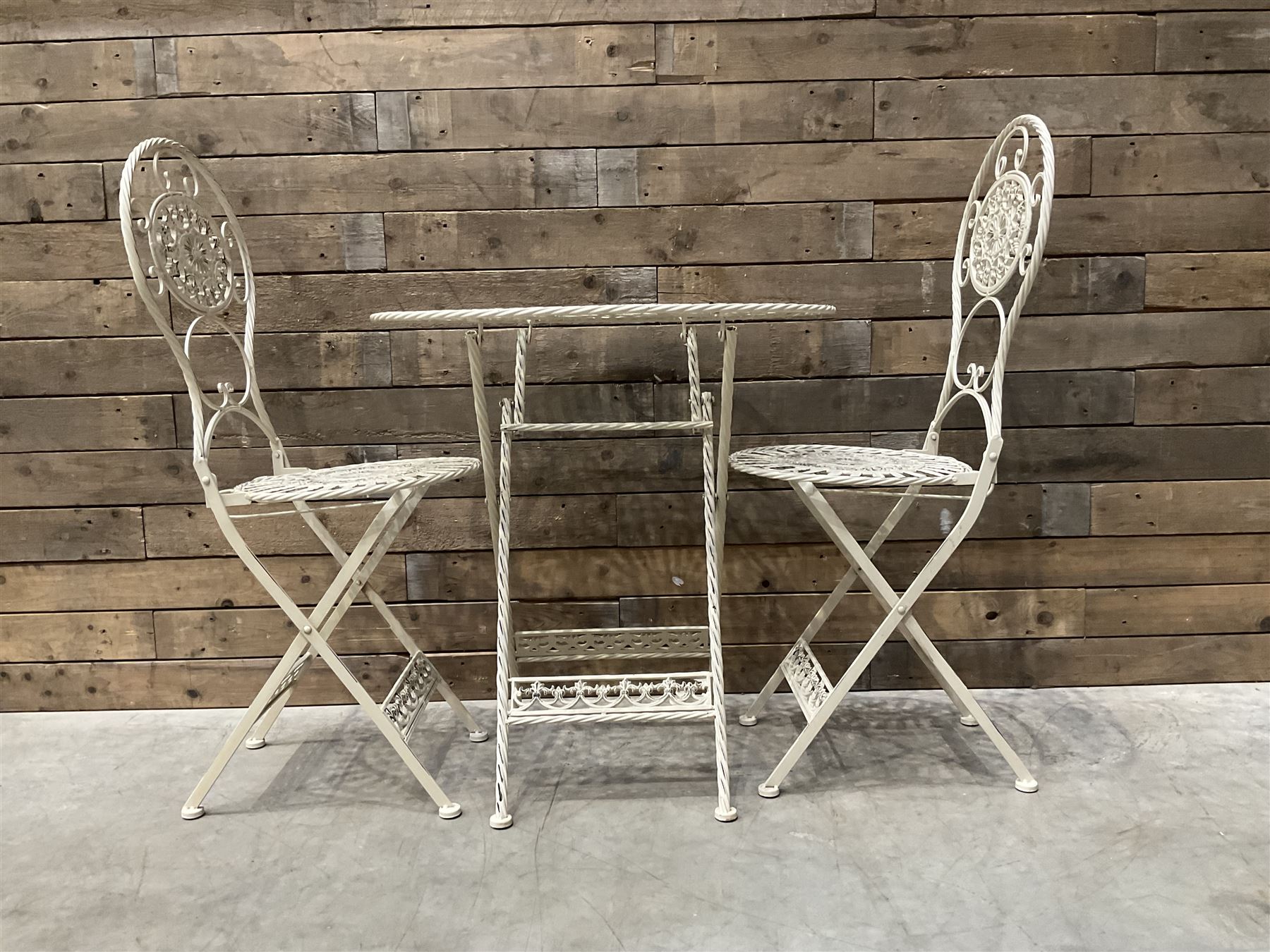 Cast metal bistro set including ornate oval garden table and two matching chairs
