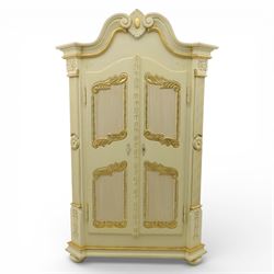 20th century French white and parcel gilt painted armoire, the shaped and scroll moulded cornice centred with a stylised foliate, the double doors with raised panel reserves applied with gilt foliate scrollwork, flanked by fluted pilasters with floral capitals, opening to a fitted interior with shelving and hanging space, raised on a moulded plinth on squat bun feet