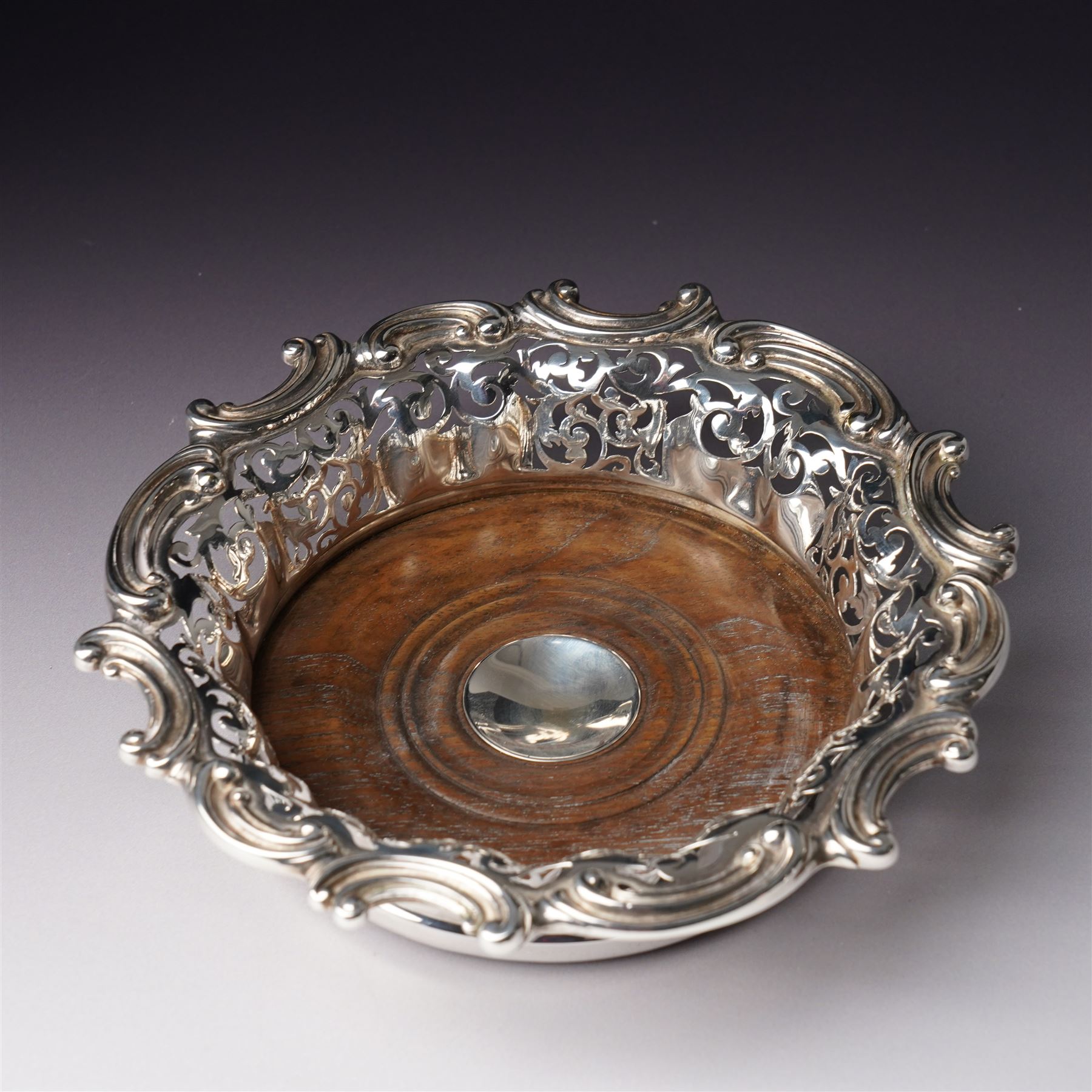 18th century Sheffield plate wine funnel by Roberts, Cadman & Co with bell mark, two other plated wine funnels and a Victorian plated bottle coaster by Elkington & Co with pierced decoration and turned wooden base (4) 