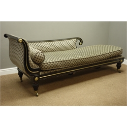  Regency ebonised chaise longue, scrolled and reeded frame, brass beading and circular mounts, turned and lobed feet with brass castors, sprung seat with seat cushion and bolster cushion upholstered in Art Deco style fabric, L223cm, H84cm, D72cm  