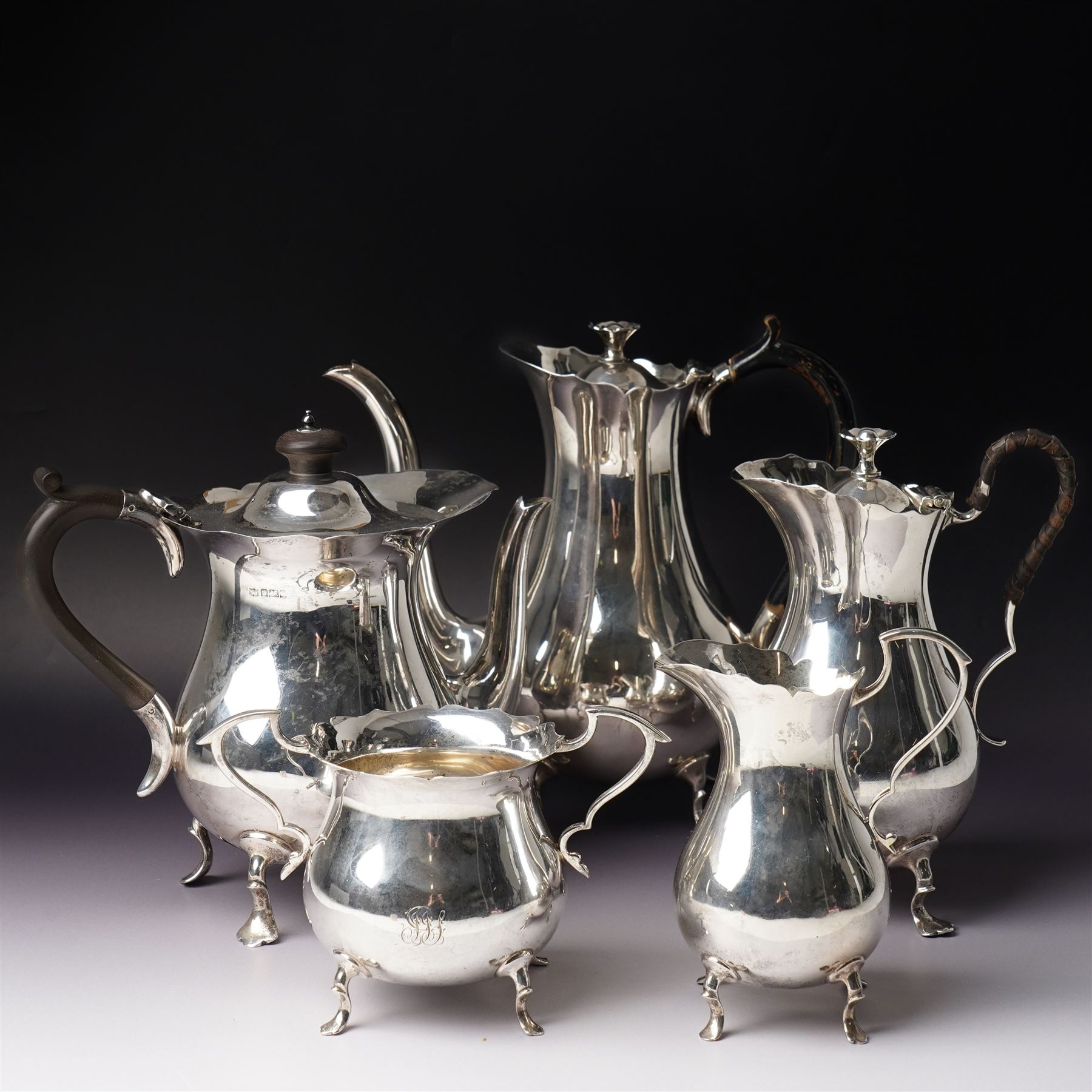 Silver matched five piece tea and coffee set of baluster form engraved with a monogram on shaped supports Sheffield 1913, the teapot 1911, the coffee pot 1924 Maker Mappin & Webb