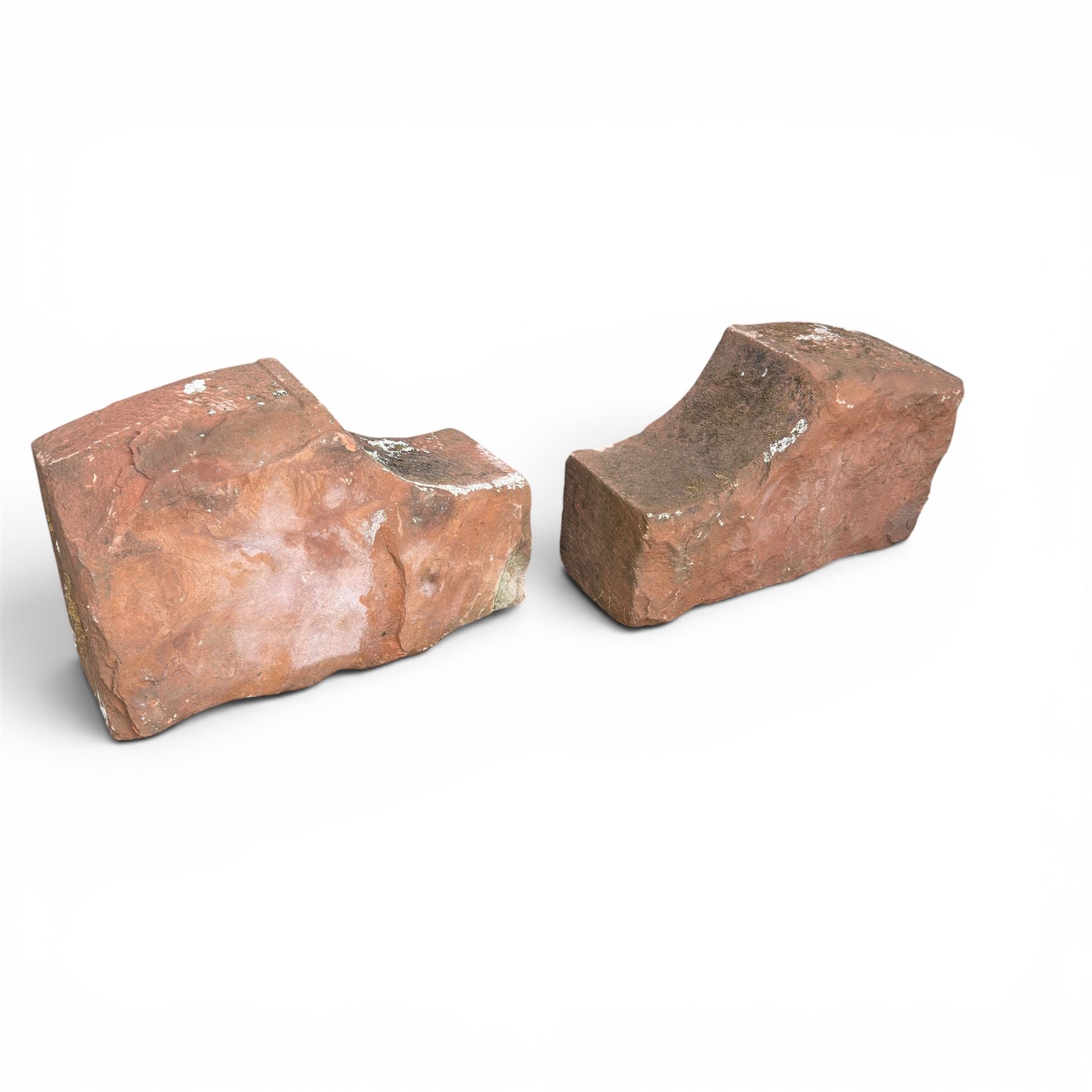 Pair of 19th century hewn and carved stone wall ends, the facias carved as shaped faux fielded panels