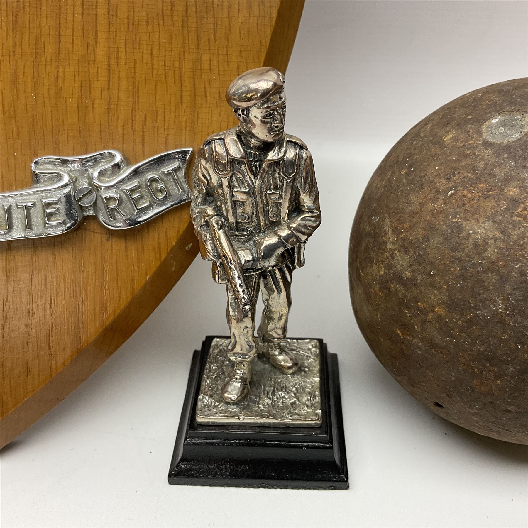 Parachute regiment - chrome crest on oak easel shield; three cloth badges; small silver plated figure; and pin badge; together with 10cm diameter cannon ball etc