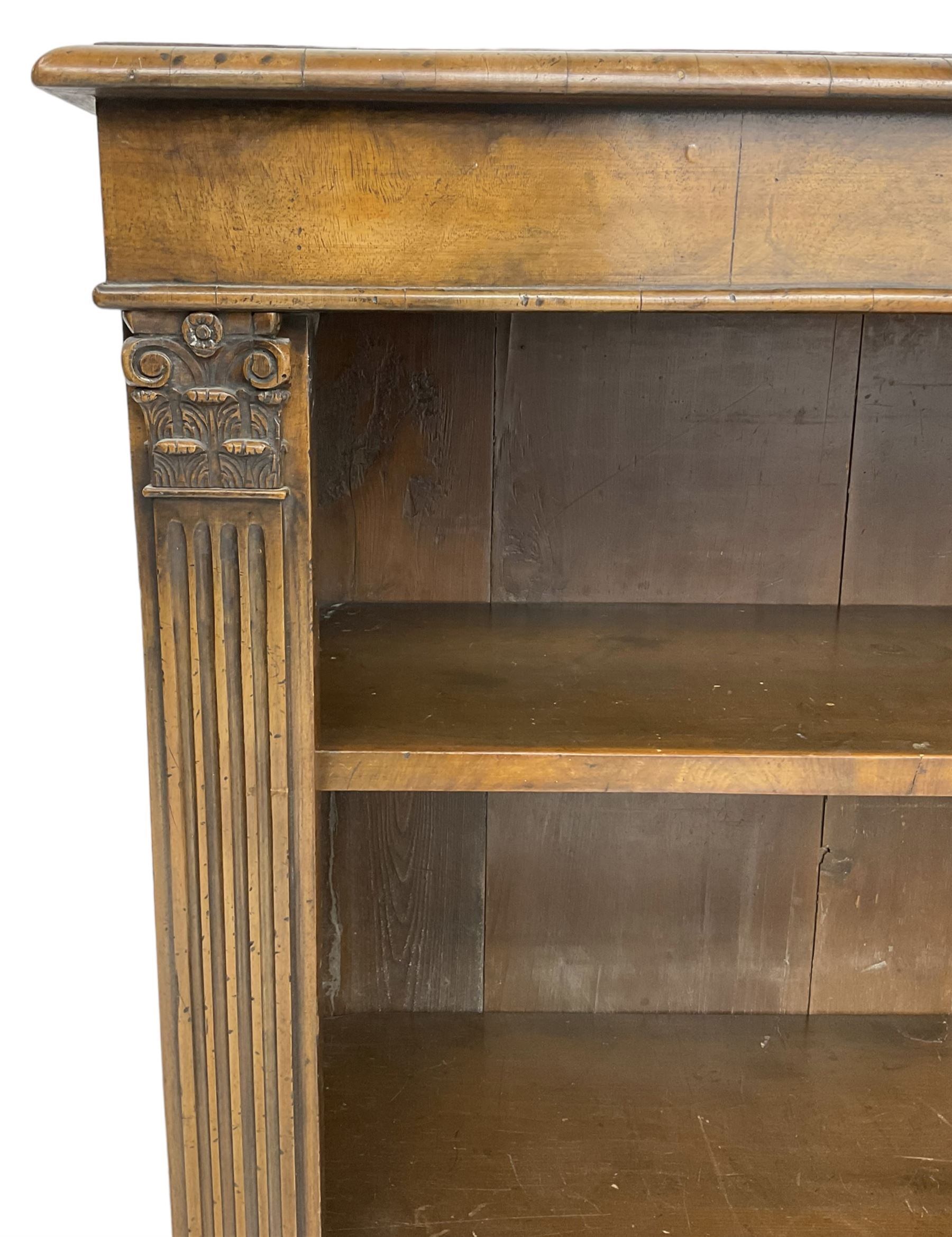 Georgian design walnut open bookcase, fluted uprights with acanthus carved capitals enclosing two adjustable shelves, on bracket feet