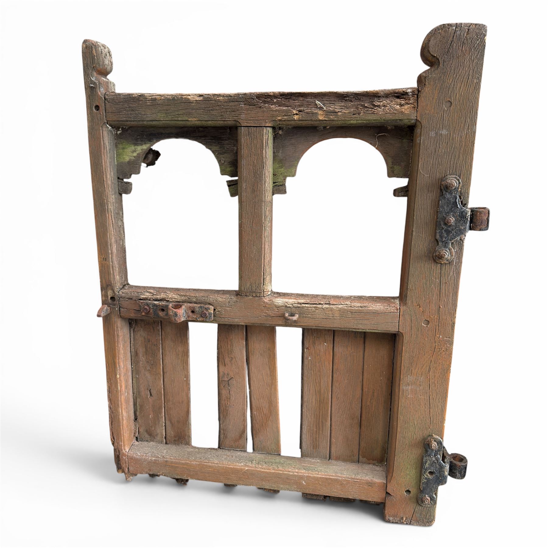 Pair of 19th century weathered wooden ecclesiastical church gates, the cresting rail over four pierced arches with slatted lower section, fitted with heavy cast iron hinges, latch and fittings