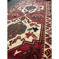Persian red ground rug, two central bird featured medallion, animal patterned field, repeated boarder 