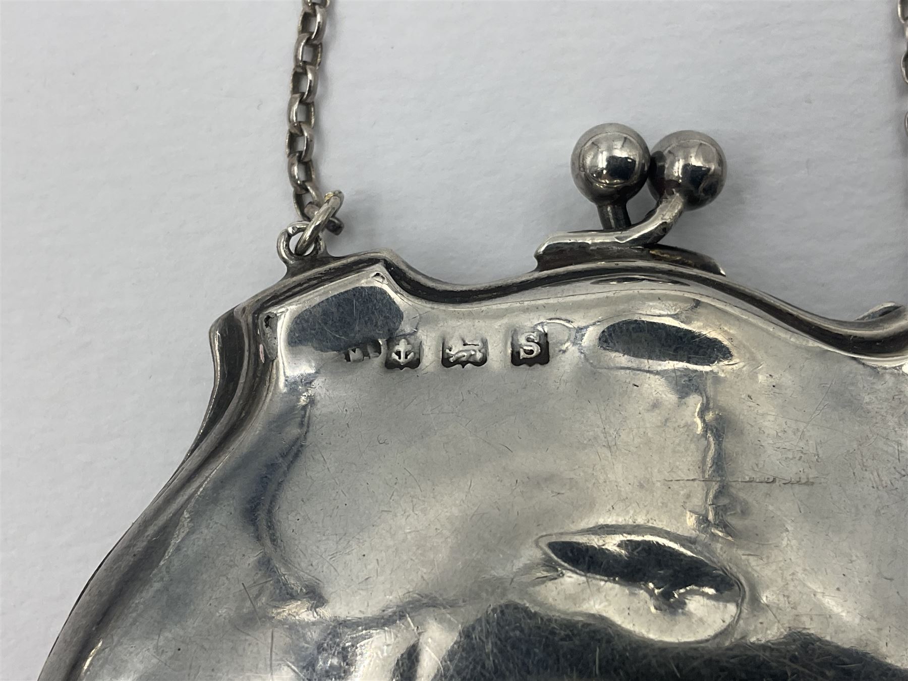 Early 20th century silver mounted coin purse, with leather interior and finger chain, hallmarked Samuel M Levi, Birmingham 1917, together with a similar Edwardian example, with engraved initials and engine turned decoration, hallmarked Birmingham 1907, maker's mark worn and indistinct, largest W11.3cm