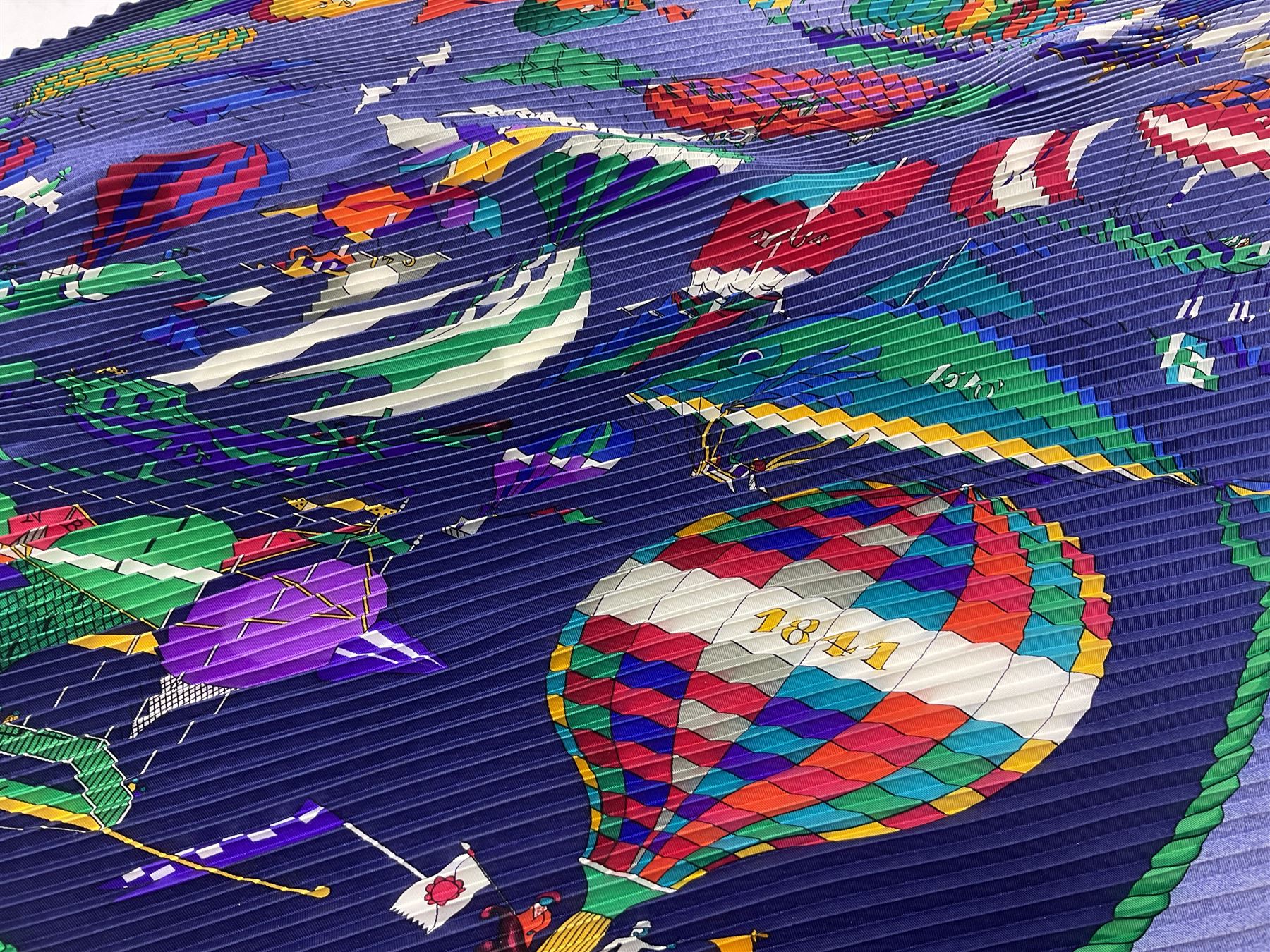Hermès 'Les Folies Du Ciel' plisse silk scarf, designed by Loïc Dubigeon, printed with hot air balloon motifs, contained within twisted green rope border, on merging light and navy blue ground, with rolled hand stitched edges and Hermes material label, length 129cm