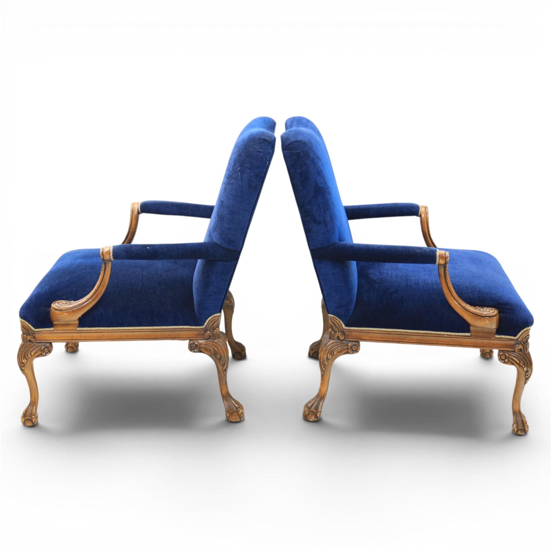 Pair of George II design Gainsborough armchairs in deep blue upholstery, shaped back over scrolled and carved arms, with cabriole supports and carved shell knees terminating in claw on ball feet
