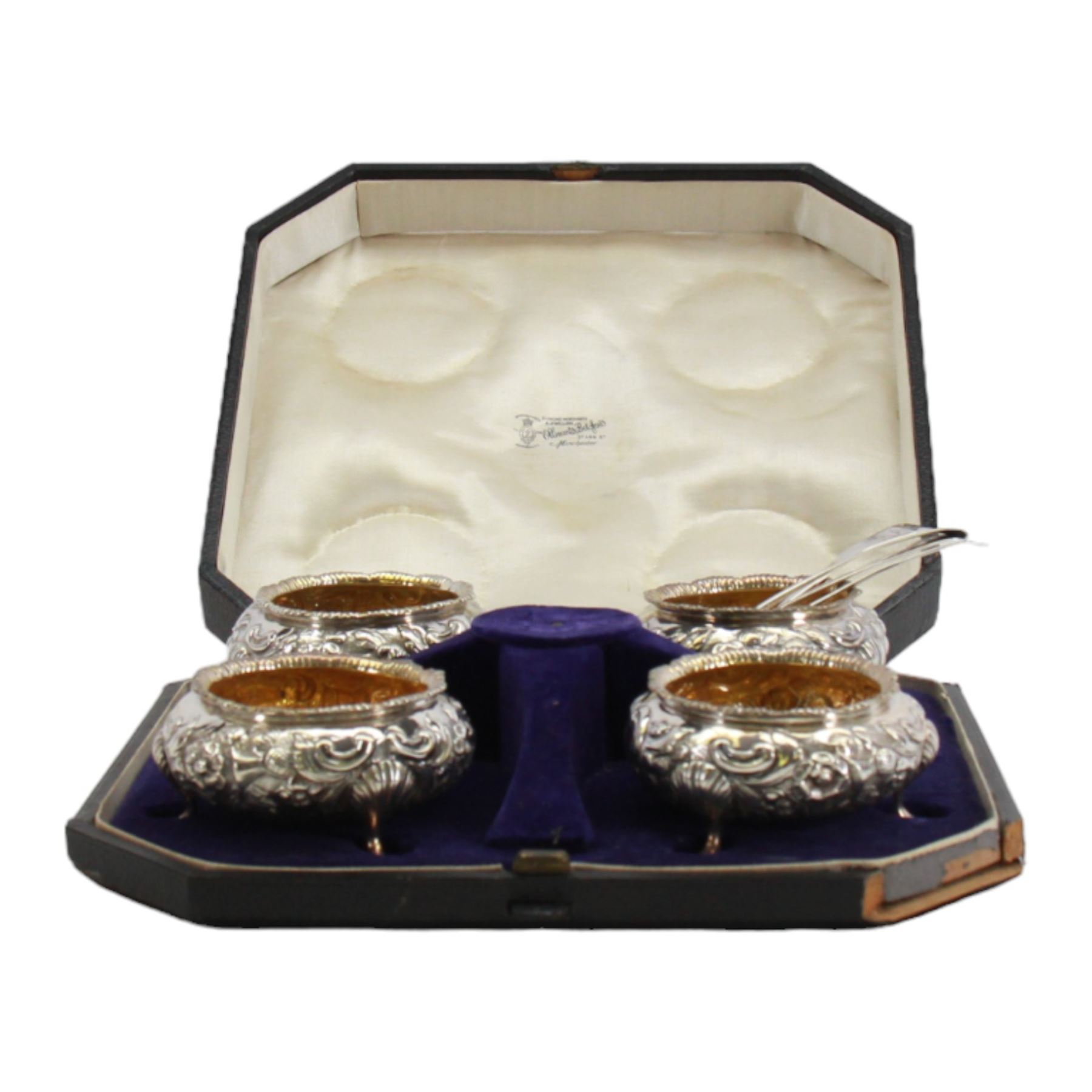 Cased set of four Victorian silver open salts, each of cauldron form with embossed foliate decoration, gadrooned rim and gilt interior, upon three hoof feet, hallmarked William Hunter, London 1844, H4cm, together with four earlier Georgian salt spoons, hallmarked London 1800, makers marks worn and indistinct, contained within a fitted case with velvet and silk lined interior
