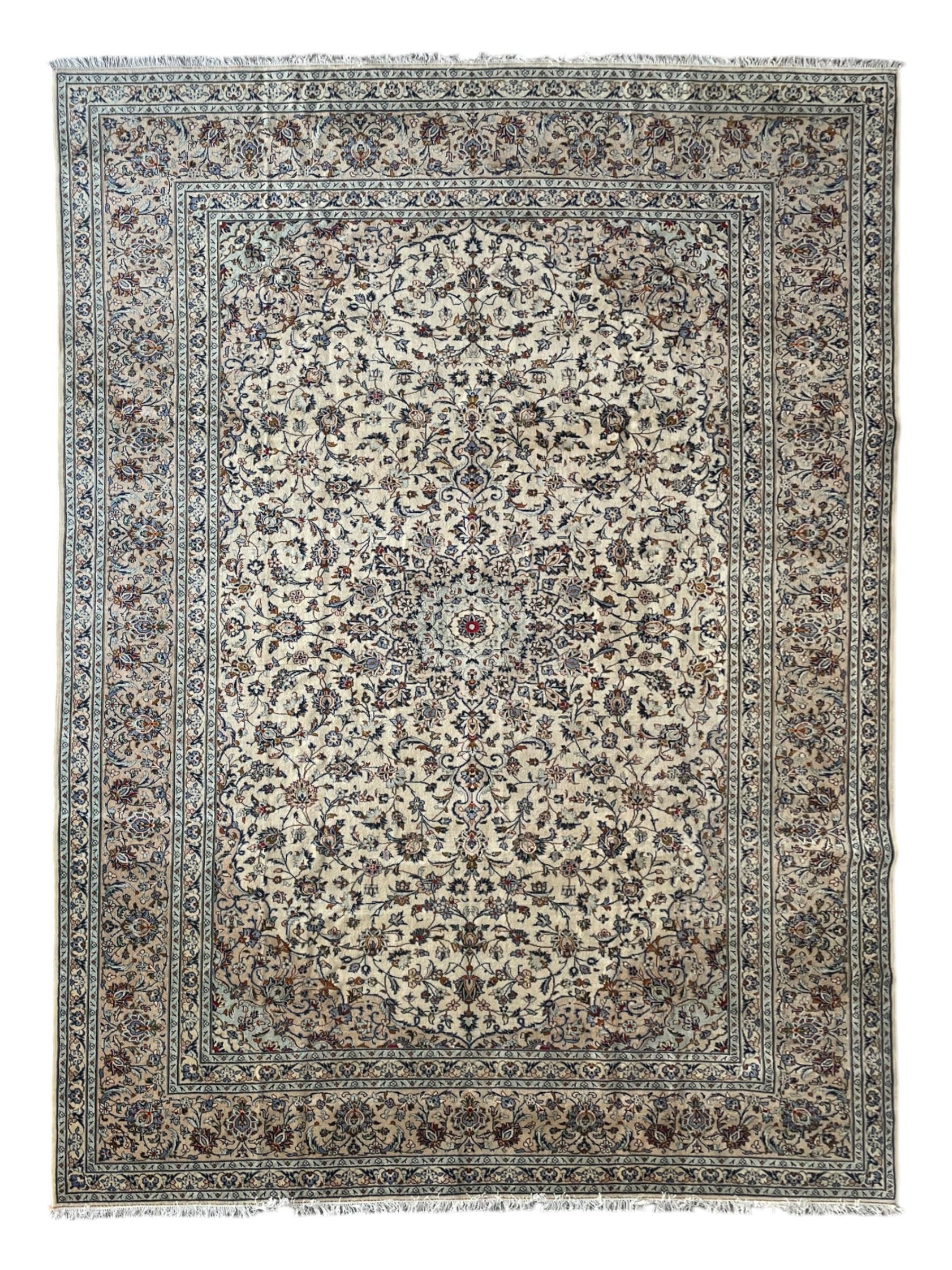 Persian Kashan ivory ground carpet, the field decorated with interlacing foliate branches and stylised plant motifs, scrolling border decorated with repeating palmettes, within floral pattern guard bands