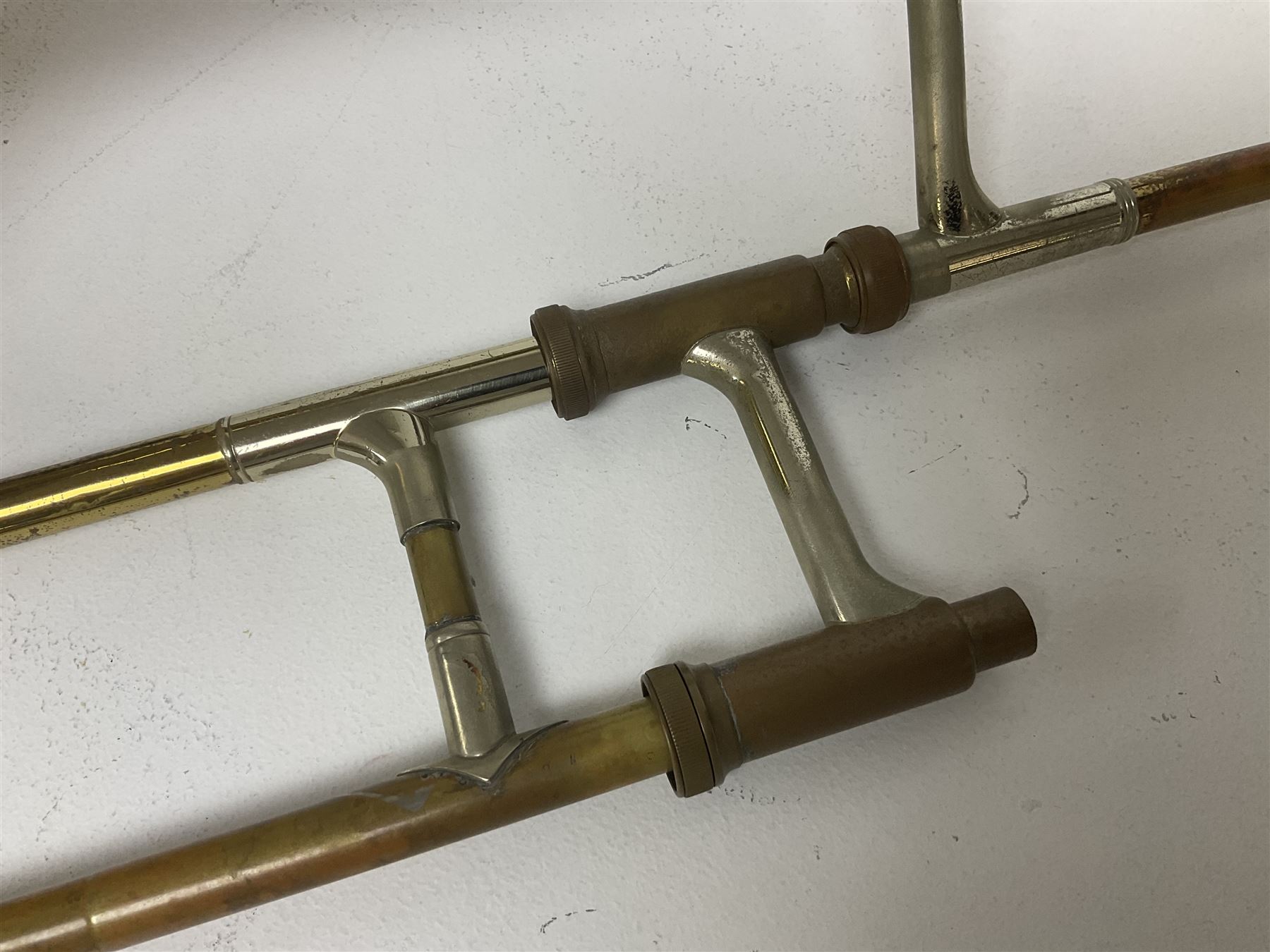 Three brass trombones comprising Elkhart Ind. USA 'CONN' model no.72H; Besson 'Concord'; and Selmer Distributed 'Lincoln'; two in carrying cases; and German B & M 'Champion' brass trumpet (4)