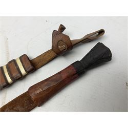 Indian kukri with 29cm curving steel blade and nickel mounted horn grip; in leather covered scabbard with one skinning knife L42cm overall; Hitler Youth knife with scabbard in relic condition; and three African graduated knives each with crudely carved wooden grips and painted leather covered scabbards (5)