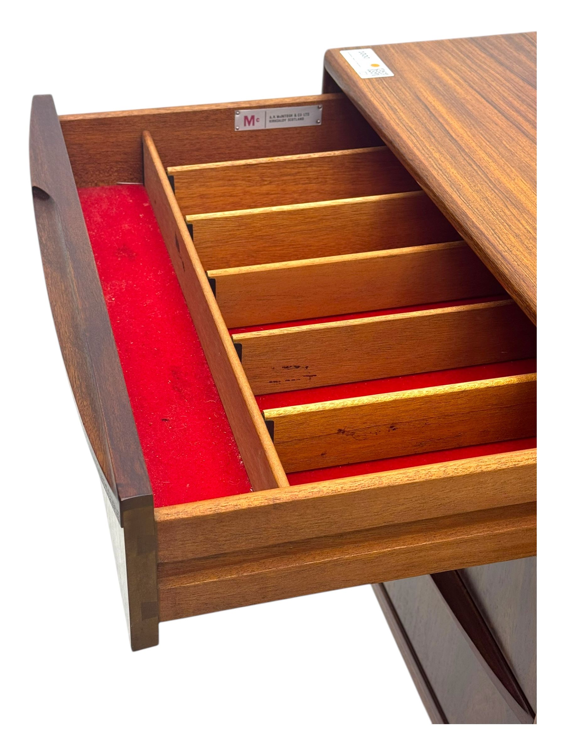 Tom Robertson for McIntosh of Kirkcaldy - mid-20th century 'Dunfermline' sideboard, the central twin cupboard doors flanked by bank of three drawers to one side and a fall front drinks cabinet to the other, raised on tapered supports