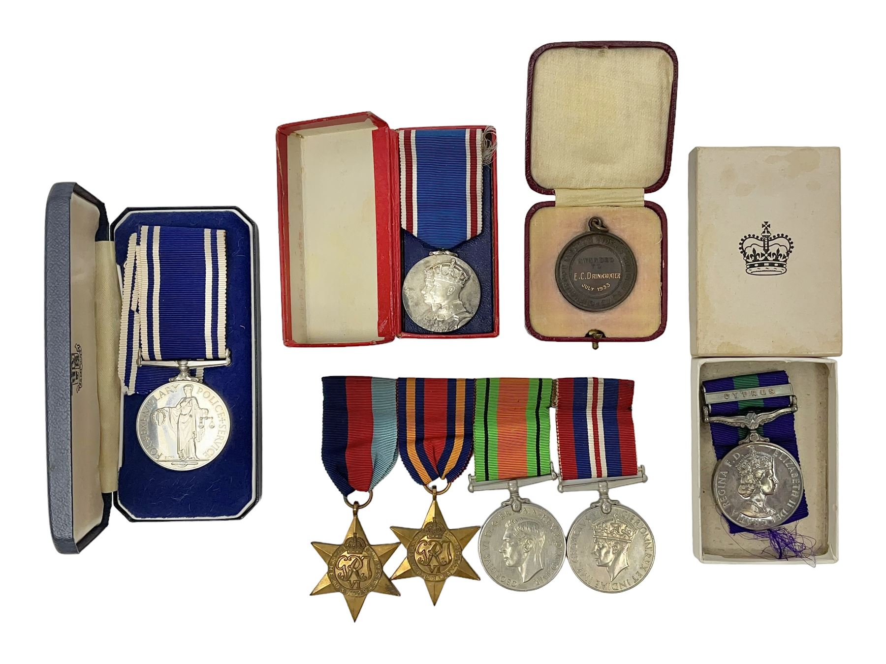 Collection of WW2 and police medals c.1933-1955, awarded to Eric Drinkwater comprising 1939-45 War Medal, Defence Medal, 1939-45 Star and Burma Star, on wearing bar; 1918-62 General Service Medal with Cyprus clasp to P.S. E.G. Drinkwater; boxed; Police Long Service and Good Conduct Medal to Const. Eric C. Drinkwater; cased; Royal Life Saving Society bronze medal to E.C. Drinkwater July 1933; boxed; and George V 1937 coronation medallion; boxed.