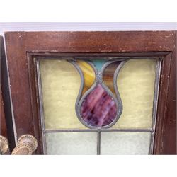 Three 20th century stained glass windows, stylised tulip mounted in a rectangular door with metal handles, with original receipt from 1921, H35.5cm  