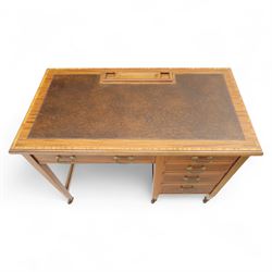 Early 20th century Edwardian mahogany single pedestal writing desk, the crossbanded rectangular top inset with brown leather, fitted with five drawers with brass swan neck handles, upon square tapering supports terminating in brass castors
