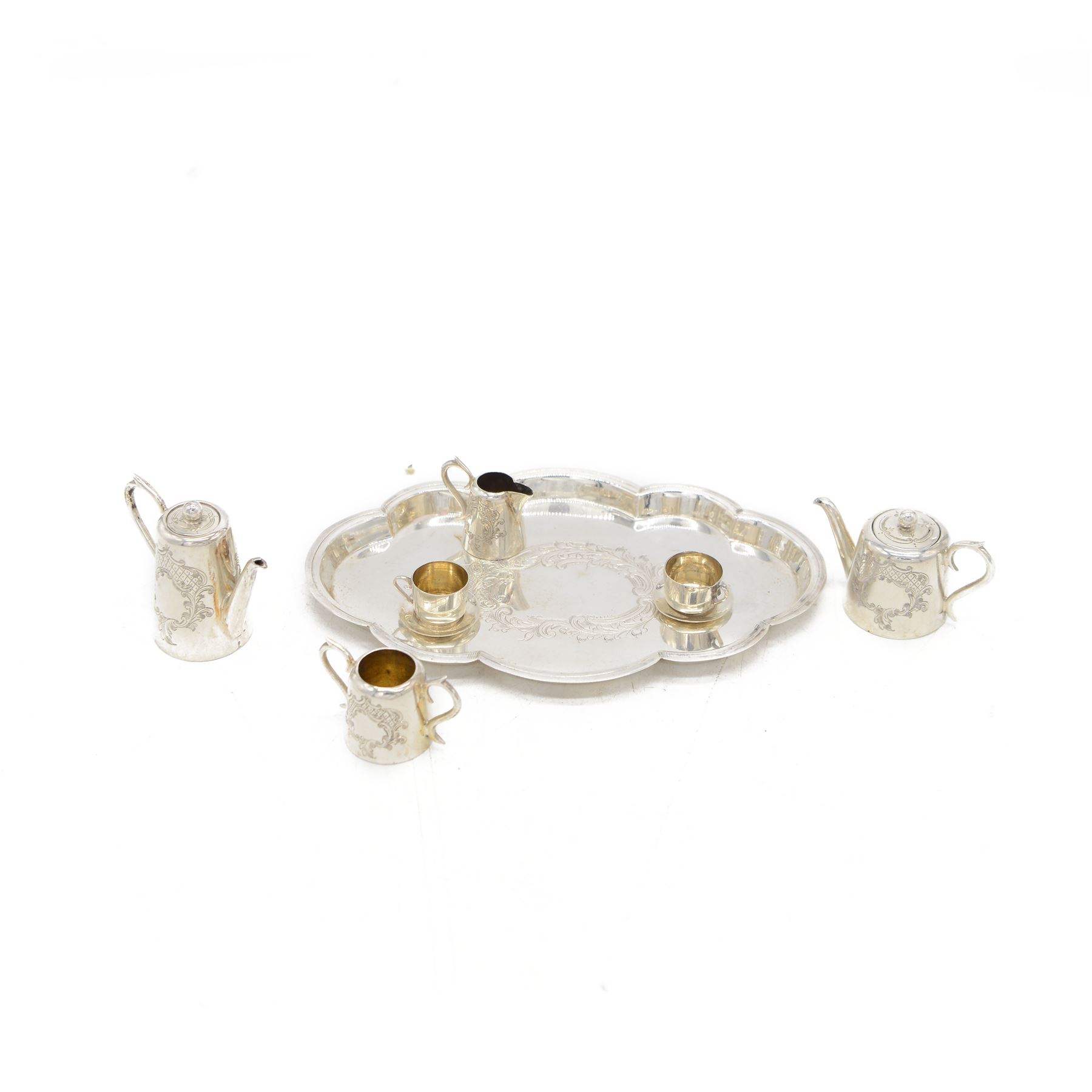 Edwardian miniature silver tea service, comprising tray, coffee pot, tea pot, milk and sugar bowl, all with engraved decoration, hallmarked J & J Maxfield Ltd, Sheffield 1903, together with a pair of miniature silver cups and saucers, hallmarked Cornelius Desormeaux Saunders & James Francis Hollings (Frank) Shepherd, Birmingham 1904, coffee pot H5cm