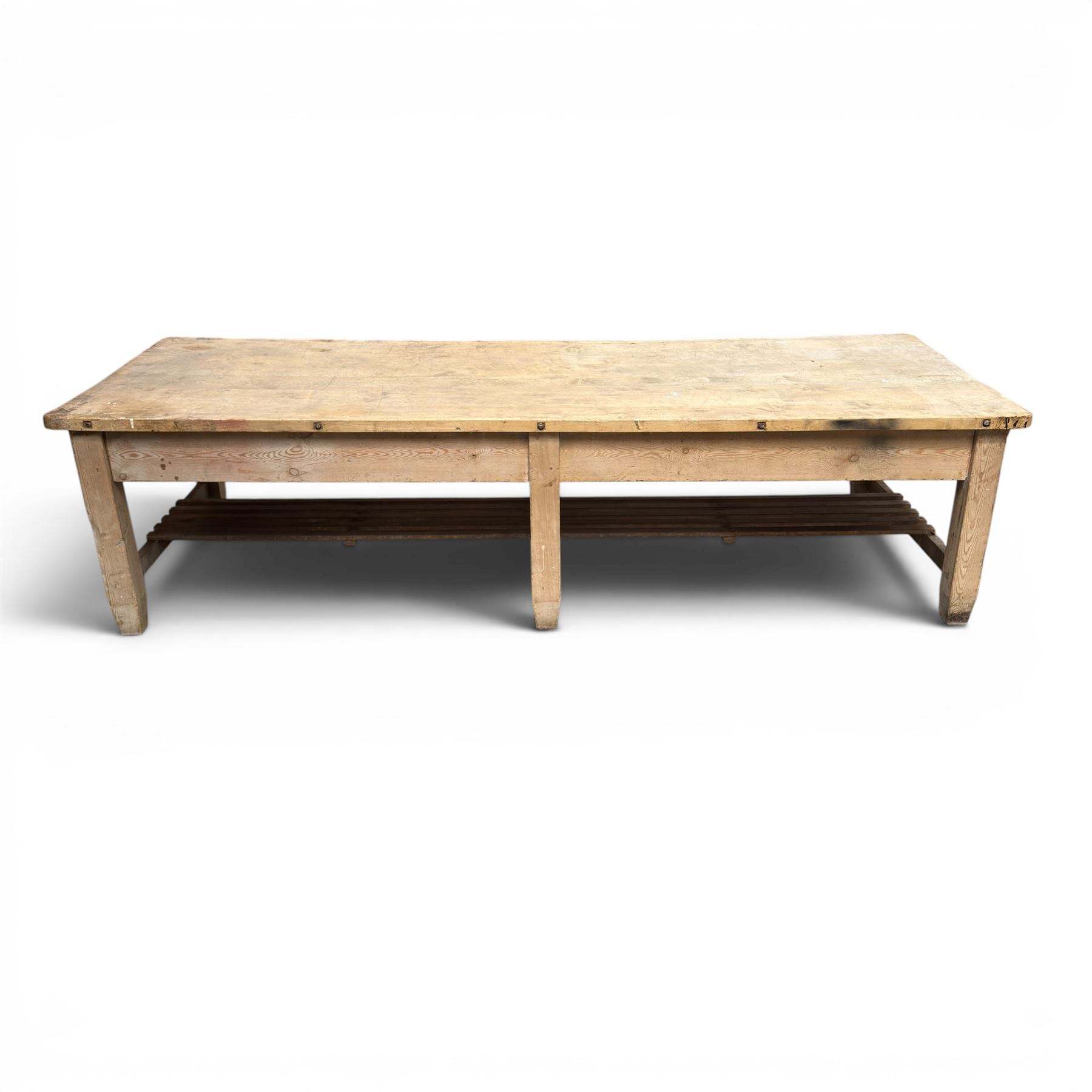 Large early/mid-20th century pine table or work bench, rectangular six plank top on eight tapering supports joined by slatted undertier