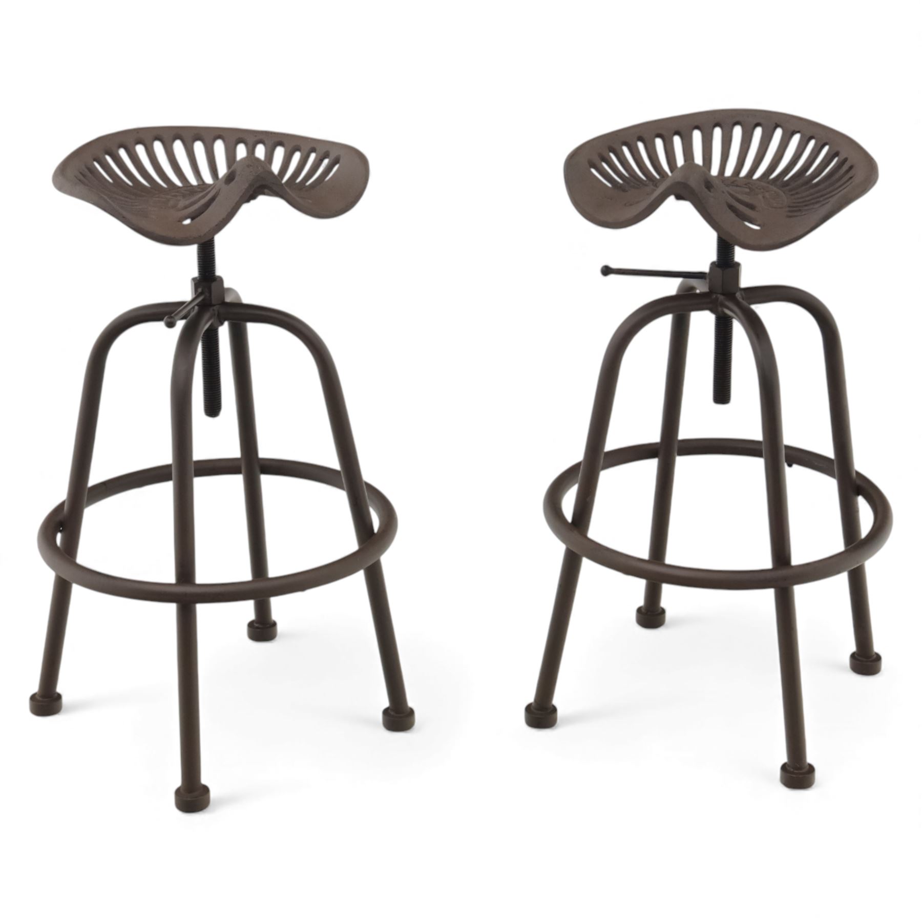 Industrial design pair of cast metal 'tractor seat' revolving bar stools, each with pierced tractor seat shaped top from the early 20th century, raised upon tubular steel supports with circular footrests (Height adjustable from 77cm - 93cm)