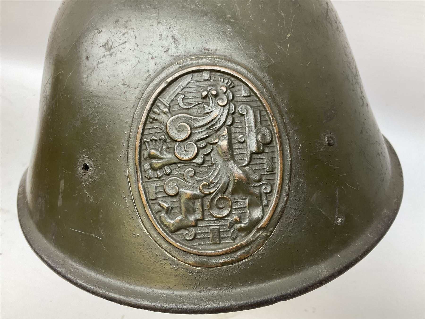 WW2 French M-26 Adrian Pattern Steel Helmet, original olive drab paint finish; flaming grenade badge to the front signifying issue to an Infantry regiment; original leather liner and leather chinstrap; and WW2 Dutch steel helmet with liner and chin strap (2)