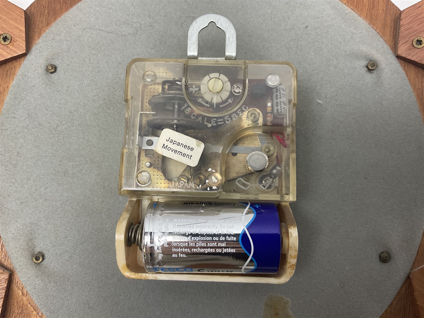 Mid-century teak sunburst wall clock by Anstey & Wilson, modelled with angular teak rays spreading from circular mount with plain brass face with Roman numerals, with battery operated Japanese movement, D45cm