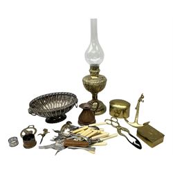 Early 20th century brass oil lamp, with embossed foliate decoration and clear glass chimney, together with group of assorted metalware, including silver plated oval bowl with twin lion mask ring handles, small quantity of flatware, etc., in one box 