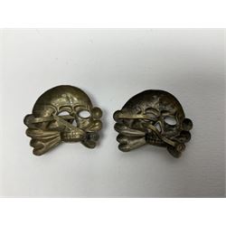 Five German 'SS' visor cap metal badges comprising one eagle and four skull and cross-bones (5)
